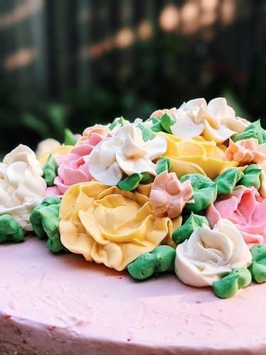 Pink cake with yellow, pink and white flowers